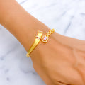 Gold bracelet with pink gemstones on a wrist against a marble background