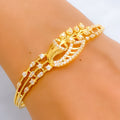 Gold bracelet with diamond accents on a wrist against a neutral background