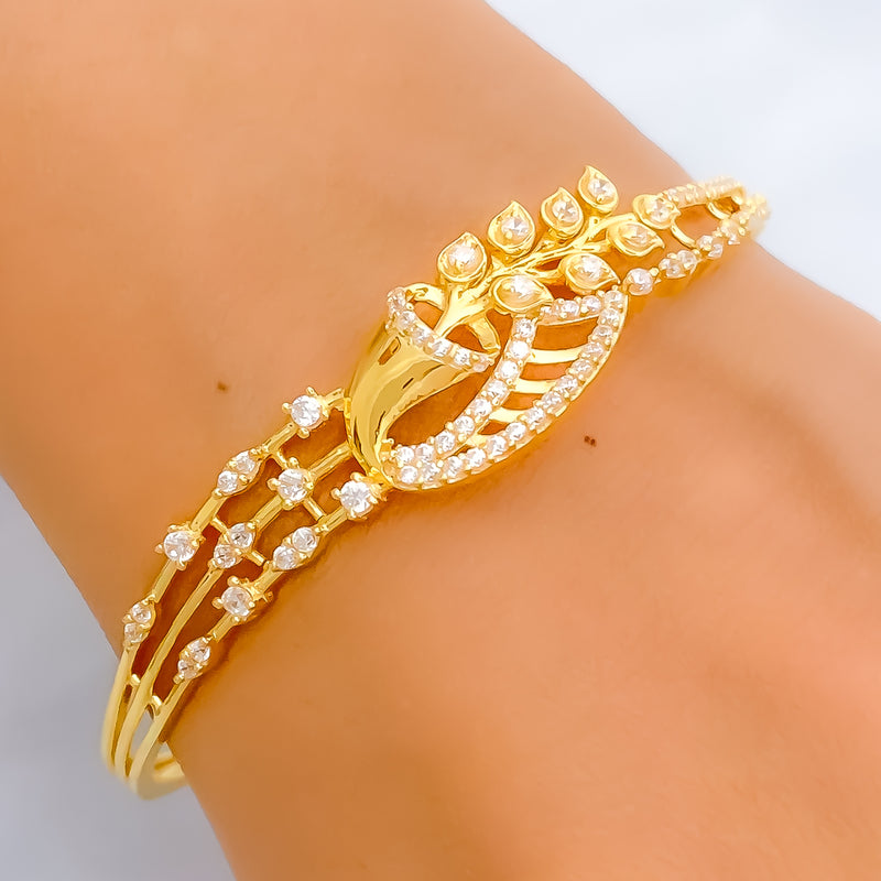 Gold bracelet with diamond accents on a wrist against a neutral background