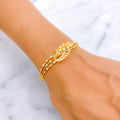 Gold bracelet on a wrist with a white marble background