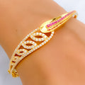 Gold bracelet with pink stones on a wrist against a neutral background