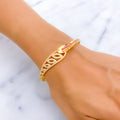 Gold bracelet with pink stones on a wrist against a marble background