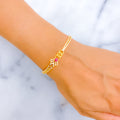 Gold bracelet with a pink gemstone on a wrist against a marble background