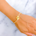 Gold bracelet on a wrist with a marble background
