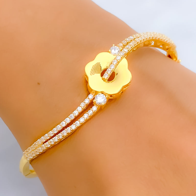 Gold bracelet with diamond accents on a wrist against a neutral background